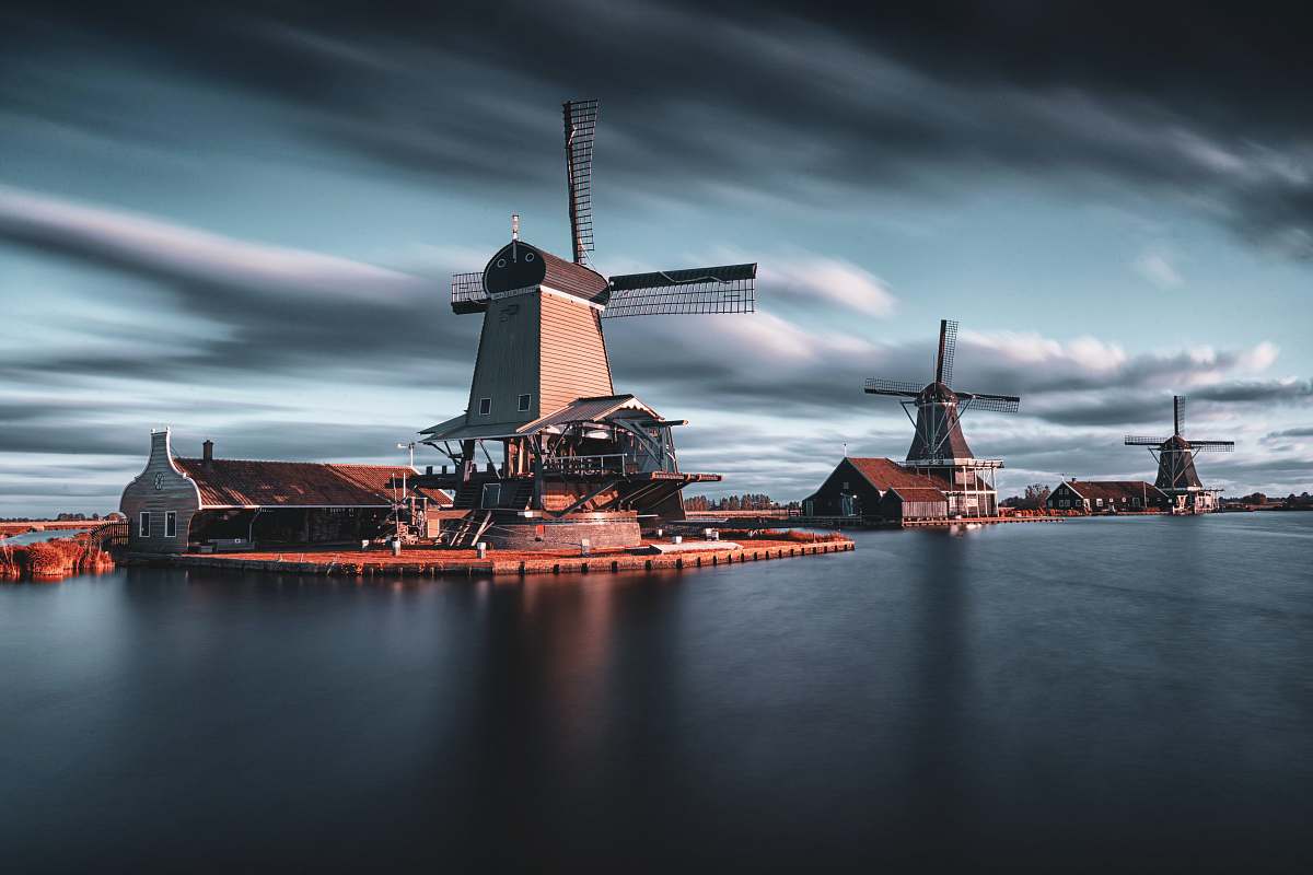 machine three windmills by the lake under grey cloudy sky motor