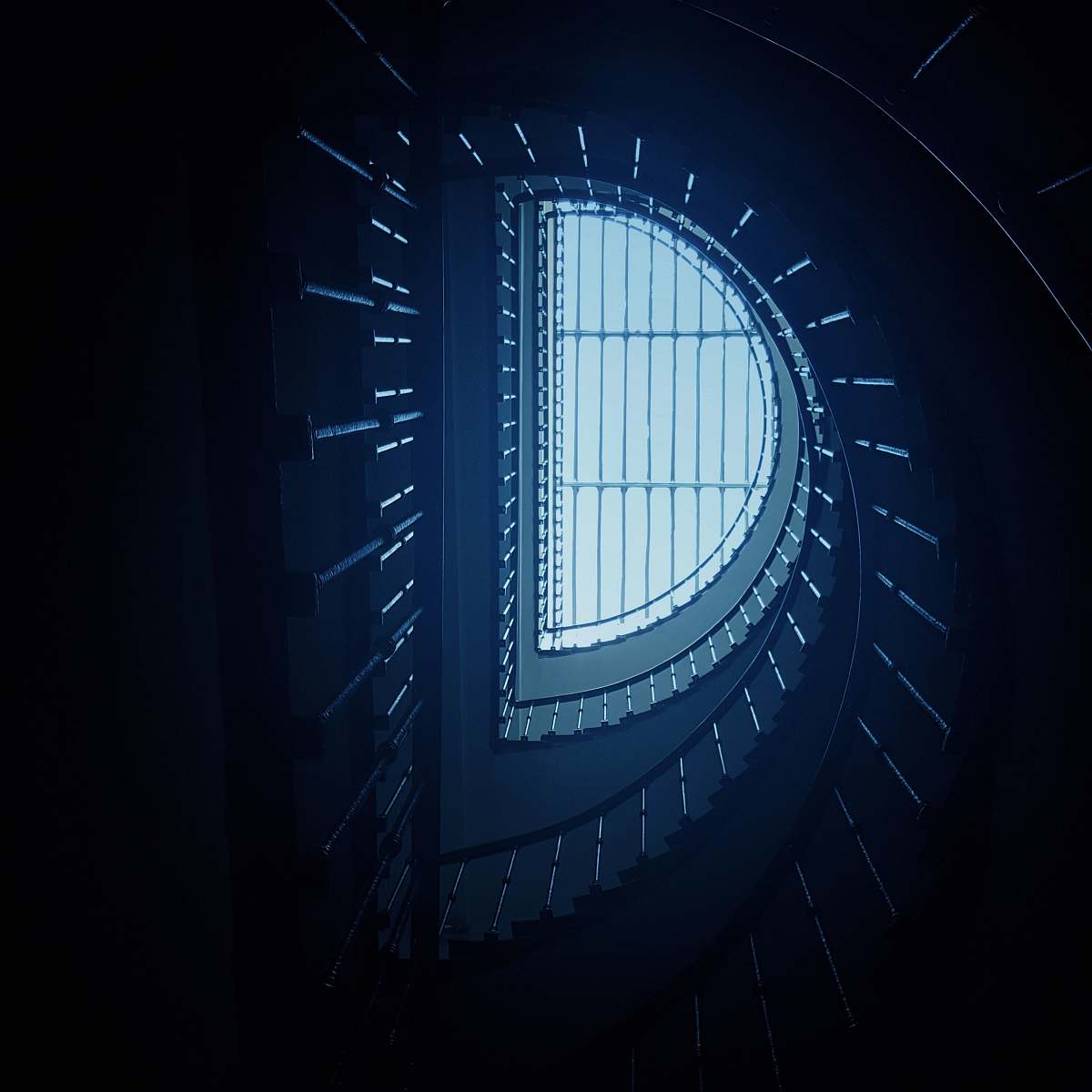 building low-angle photography of spiral stairs skylight