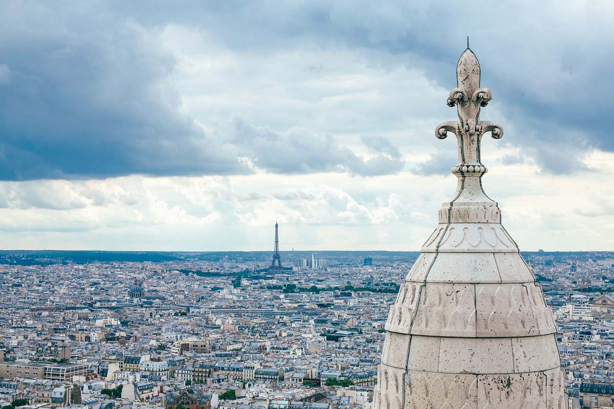 paris architectural photography of white concrete structure under cloudy sky outdoors