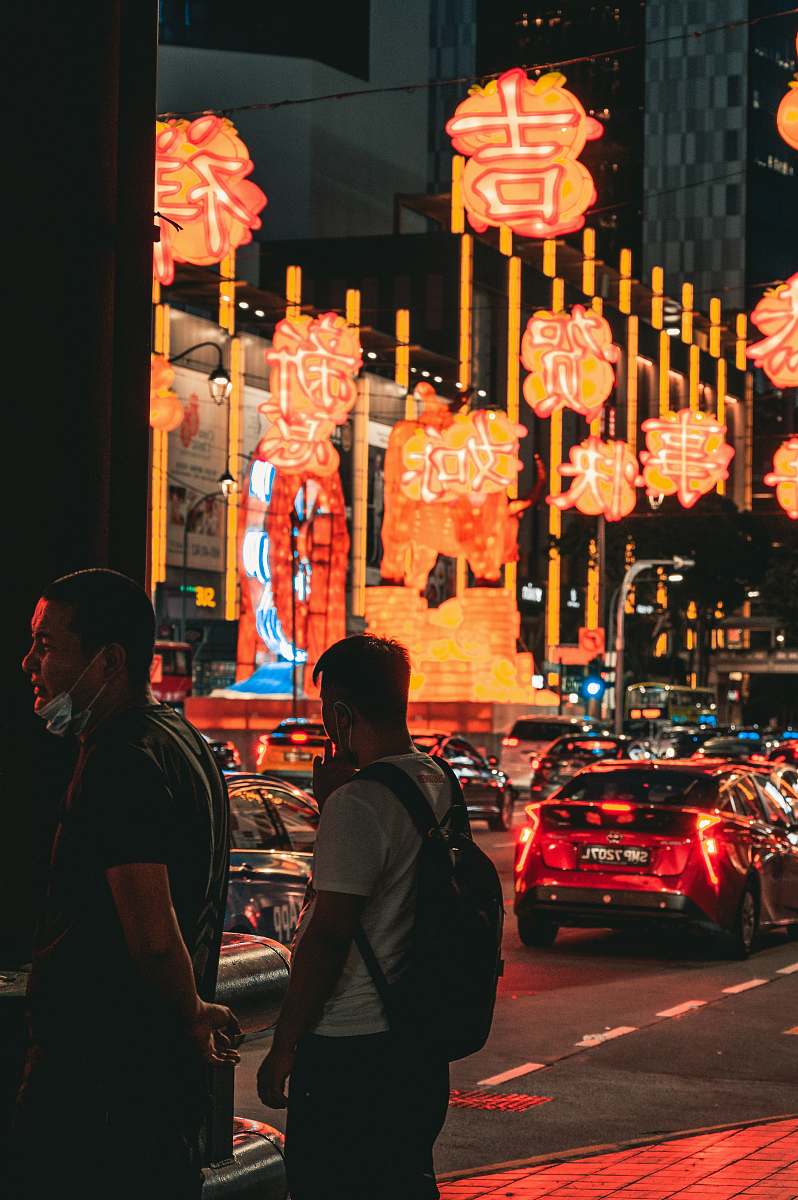 person man in black jacket standing near red car during night time automobile