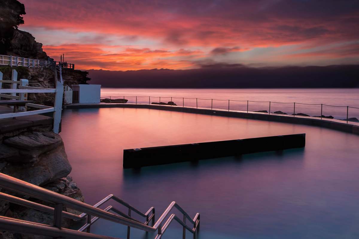 sunrise gray metal handrail beside body of water bronte