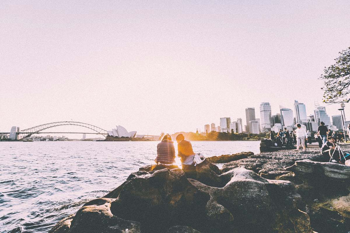 sydney people sitting and standing at shore watching the sunset near the Sydney Opera House in panorama photography sea
