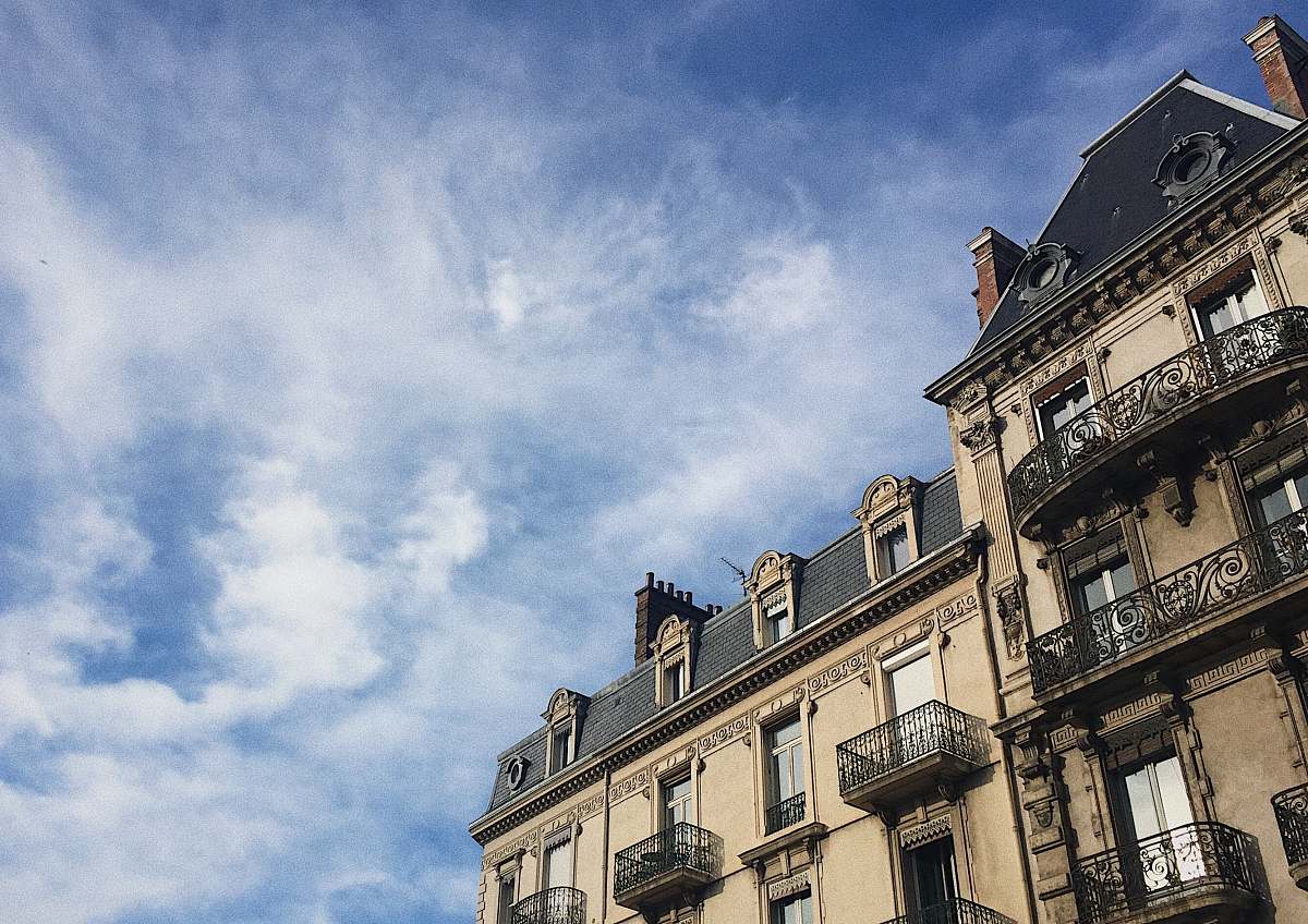 city white and black concrete building under white cloud and blue sky during daytime town