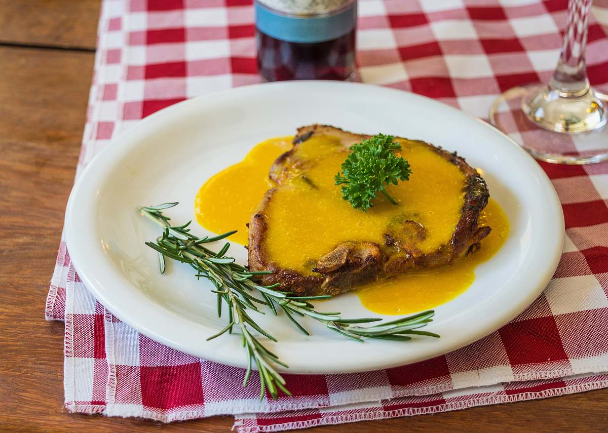 plate Cooked pork chop on round white ceramic plate cup