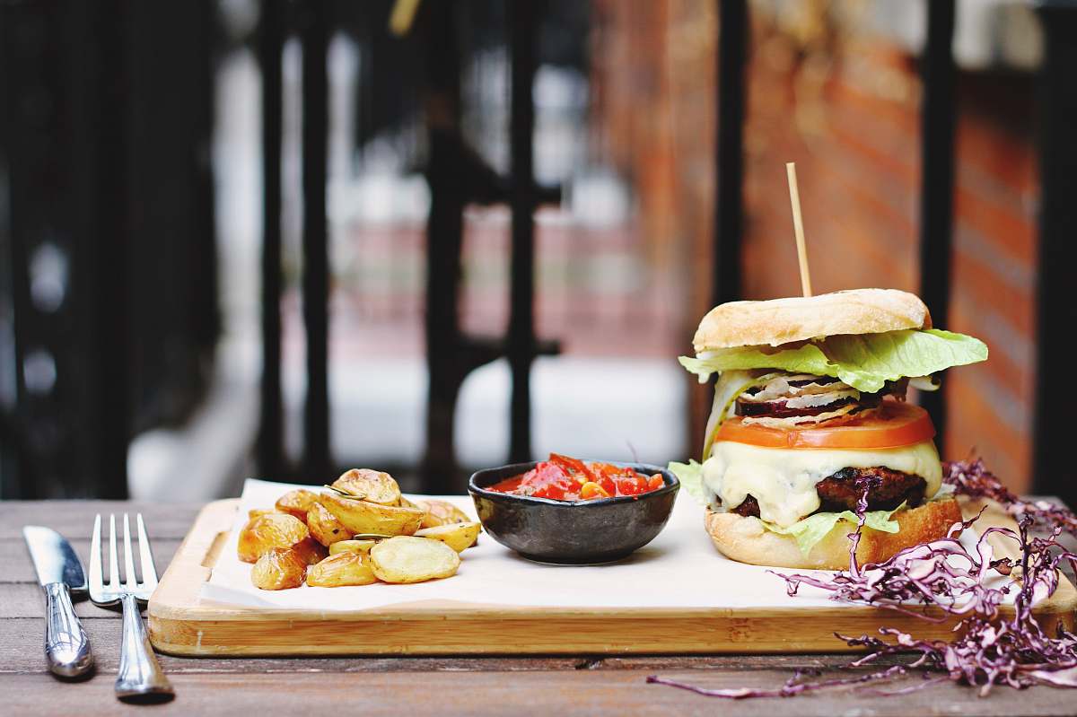 cutlery ham burger beside bowl on tray burger