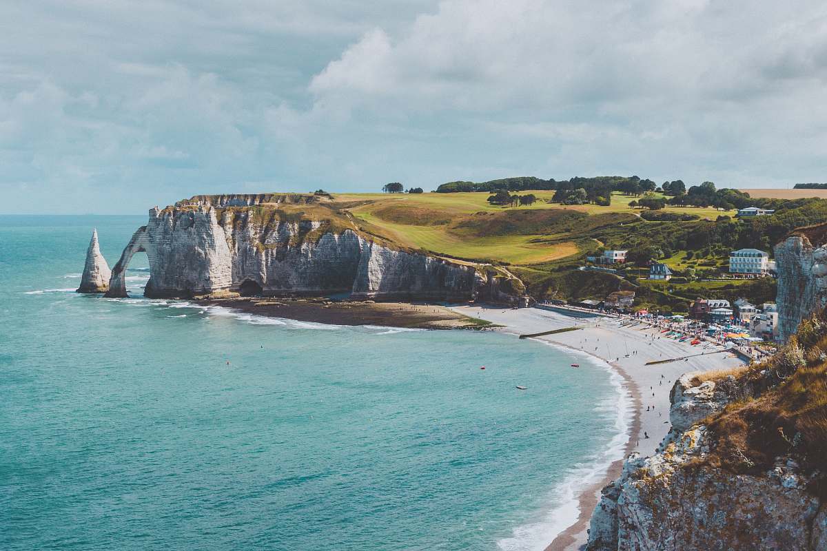 ocean body of water near mountain cliff