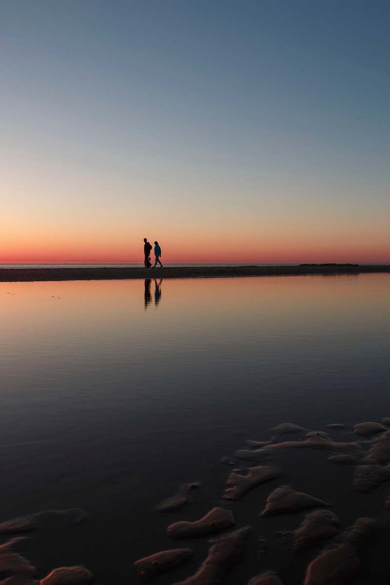 sunset two person standing on beach dock wissant