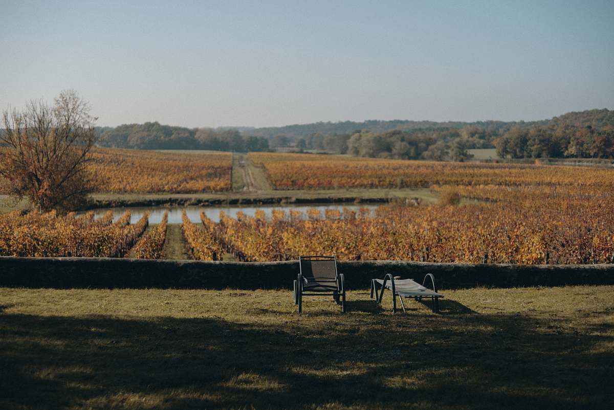 outdoors black armchair and lounger on green lawn grasses countryside