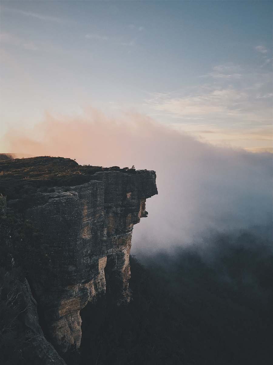 outdoors person sitting on mountain cliff cliff