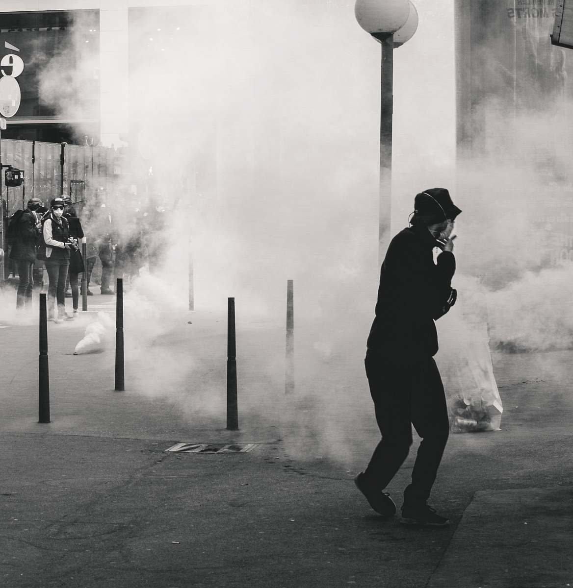 human grayscale photo of man near smoke lyon