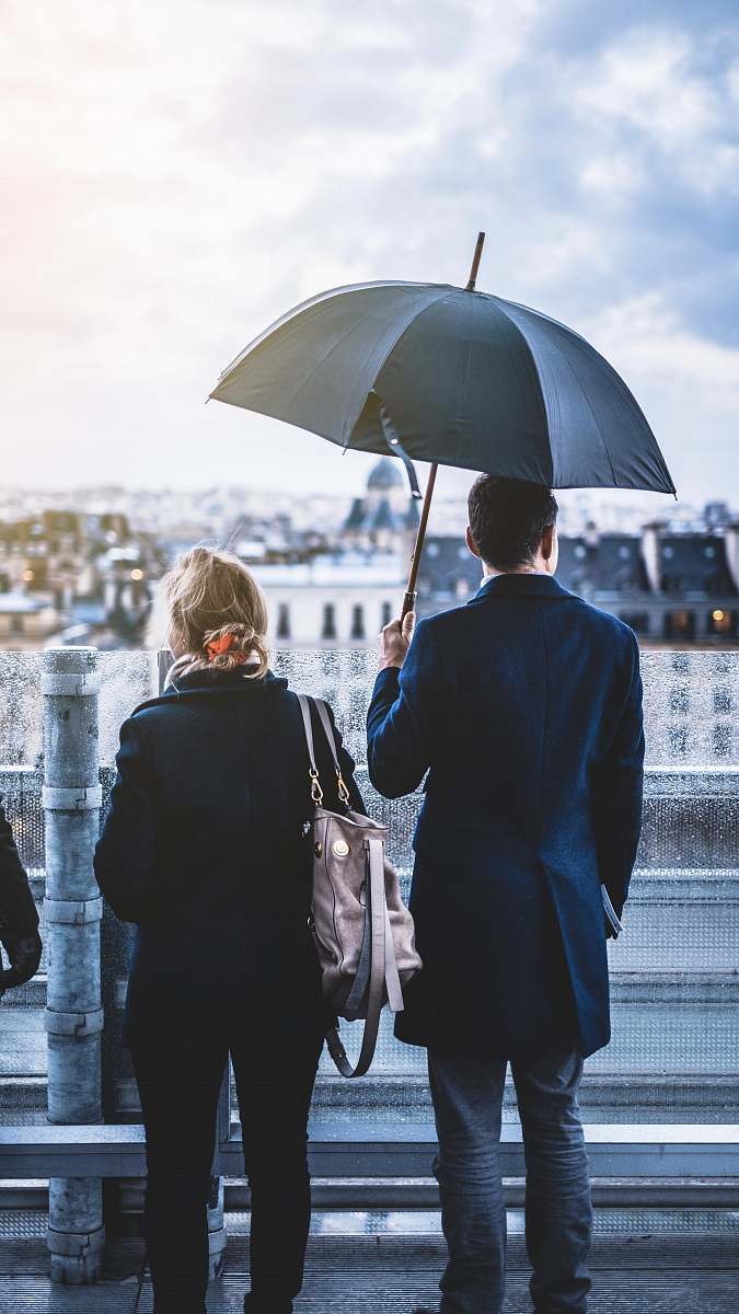 apparel man wearing black trench coat holding black umbrella clothing