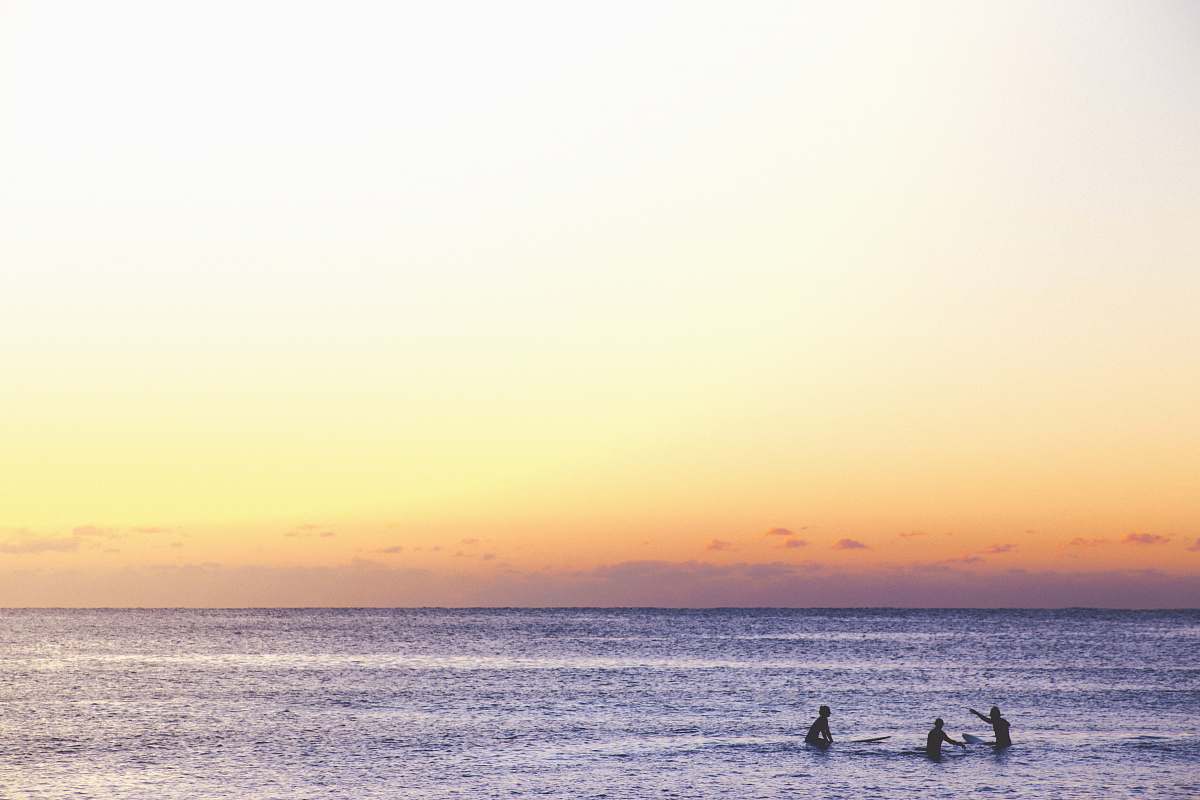ocean three person playing on ocean during golden hour australia