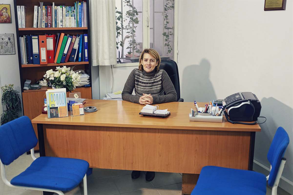 table woman sitting beside desk near bookcase with books furniture