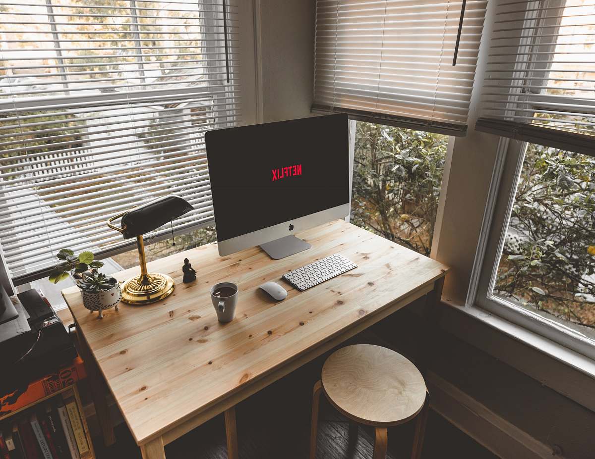 desk silver iMac, Magic Mouse, and wireless keyboard on desk neaar windows home decor