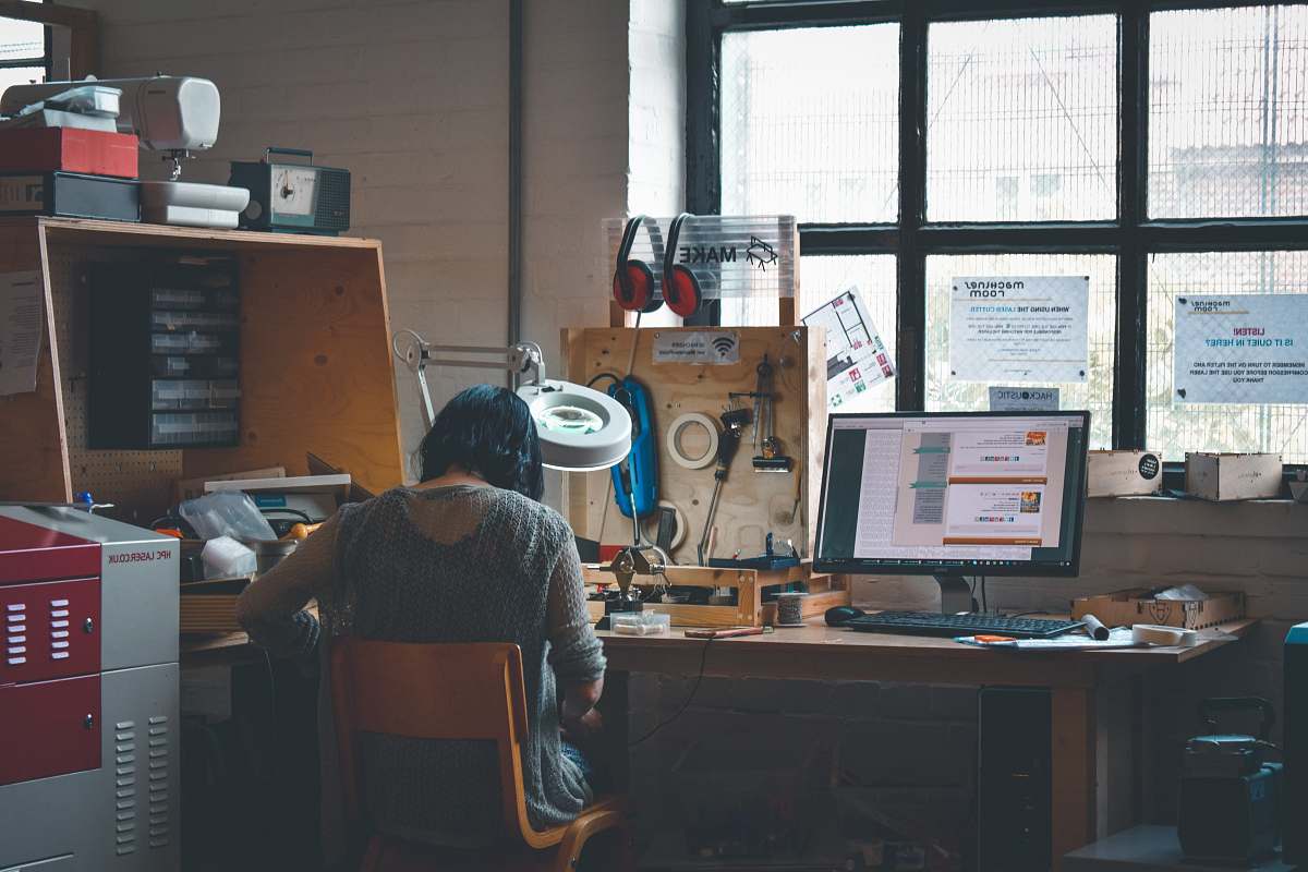 table woman sitting in front of a wooden desk person