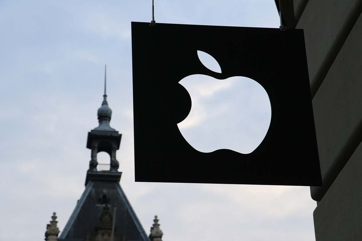person Apple logo in front of a building people