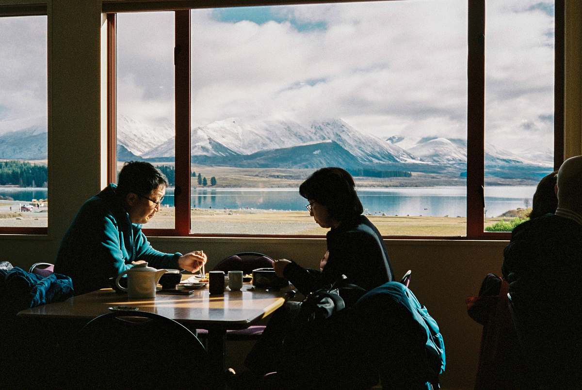 human man an woman having breakfast with the view of mountain restaurant