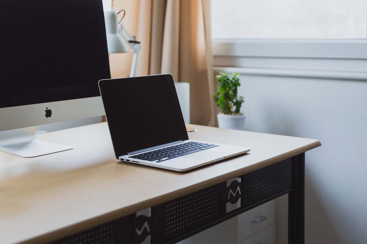 computer silver laptop on desk beside silver iMac laptop