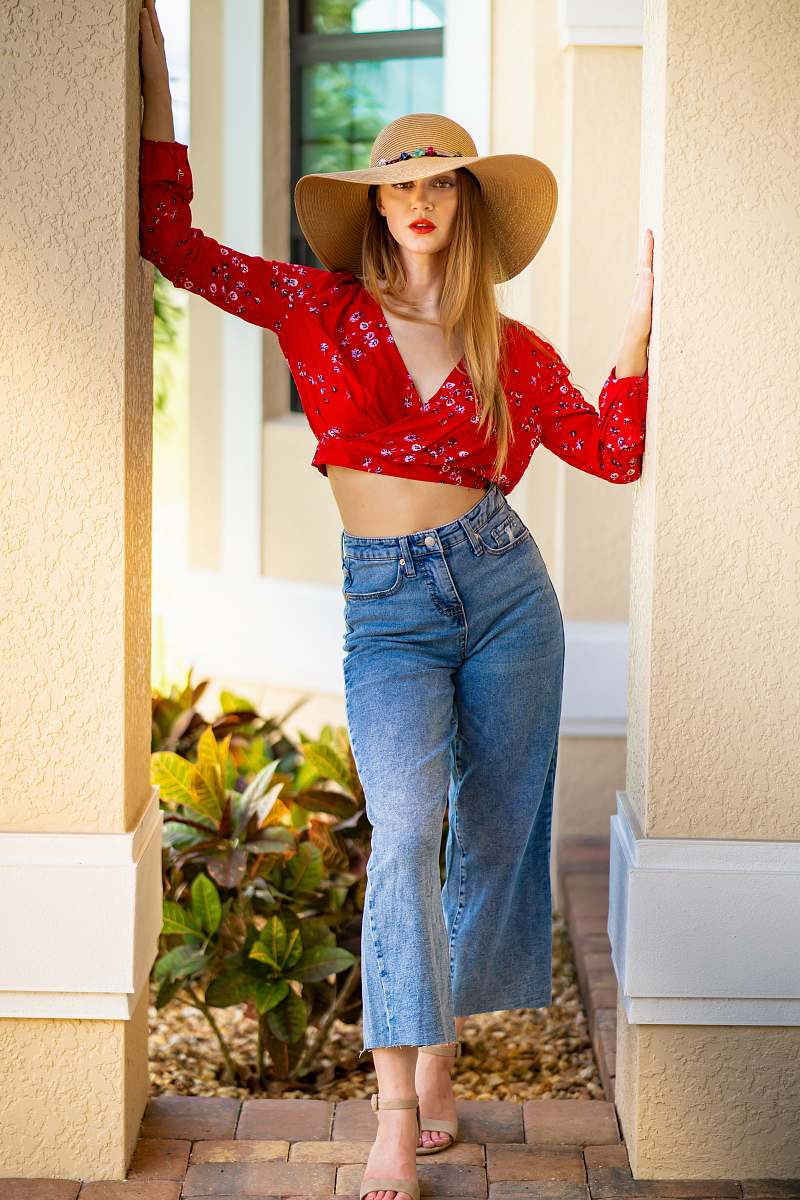 hat woman wearing sun hat, red crop top, and blue jeans cowboy hat