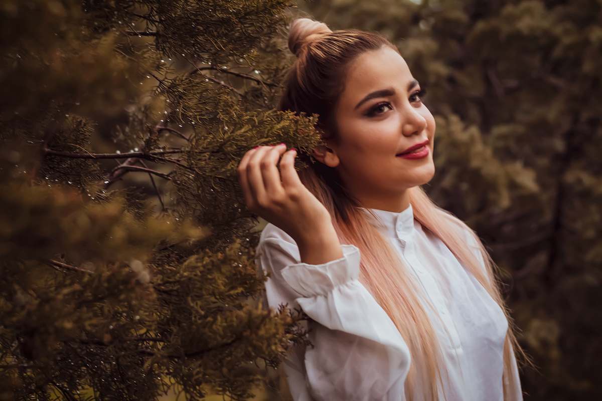 person woman wearing white blouse standing beside tree female