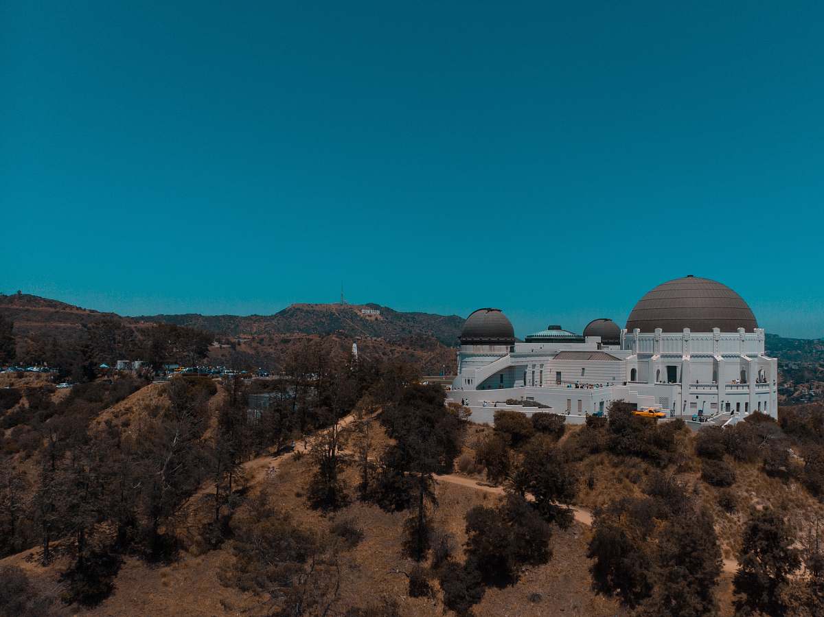 architecture white dome building on brown and green mountain under blue sky during daytime building