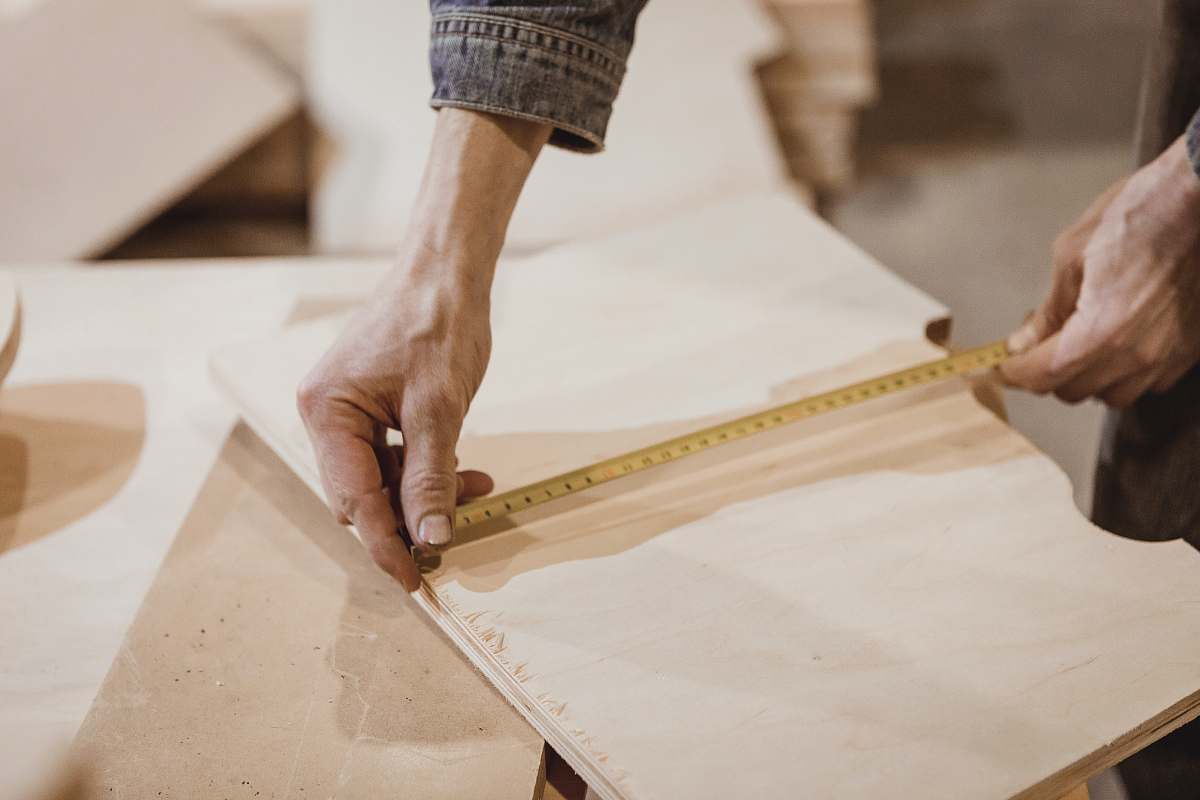 plywood person measuring brown board human