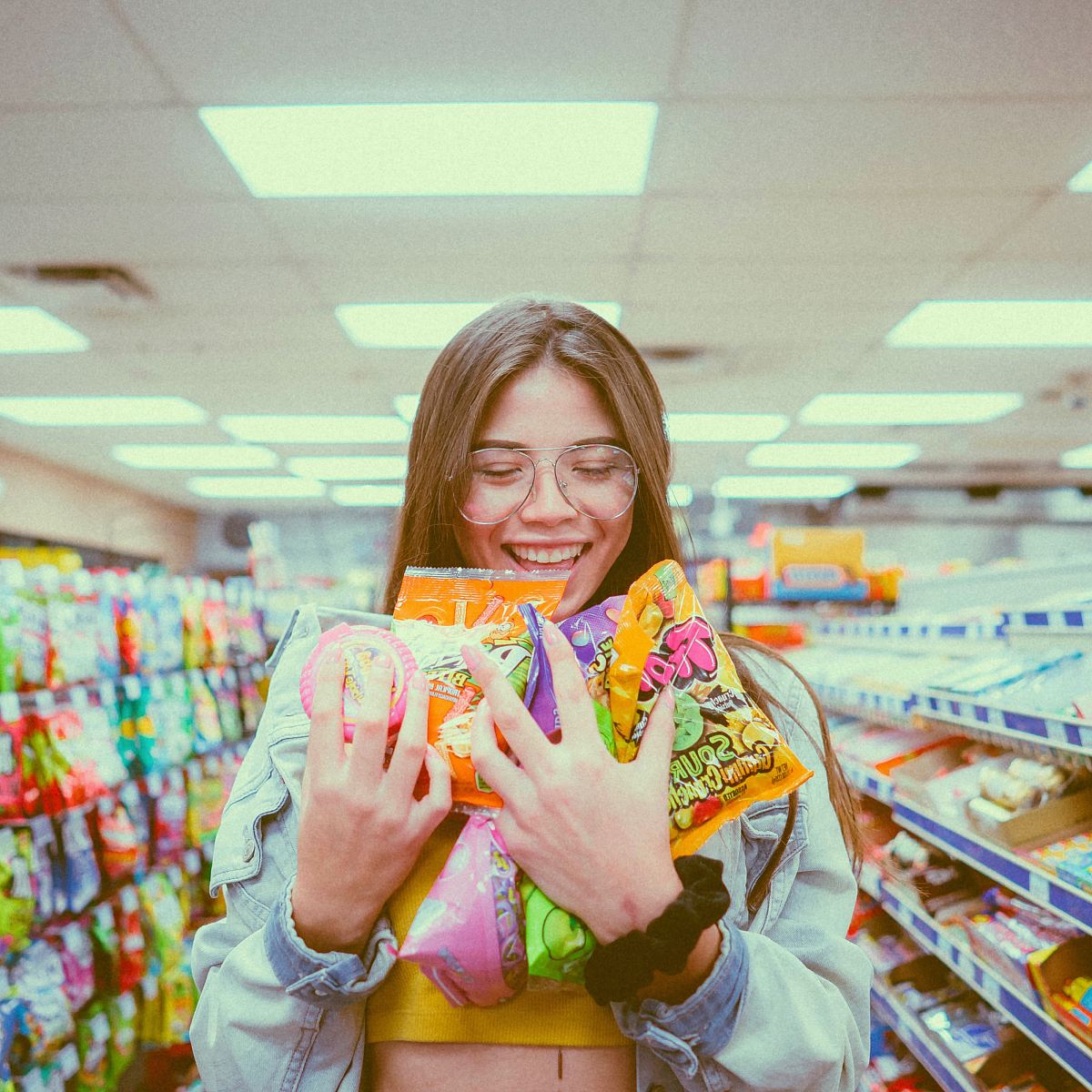 smiling woman holding pack of food inside grocery store