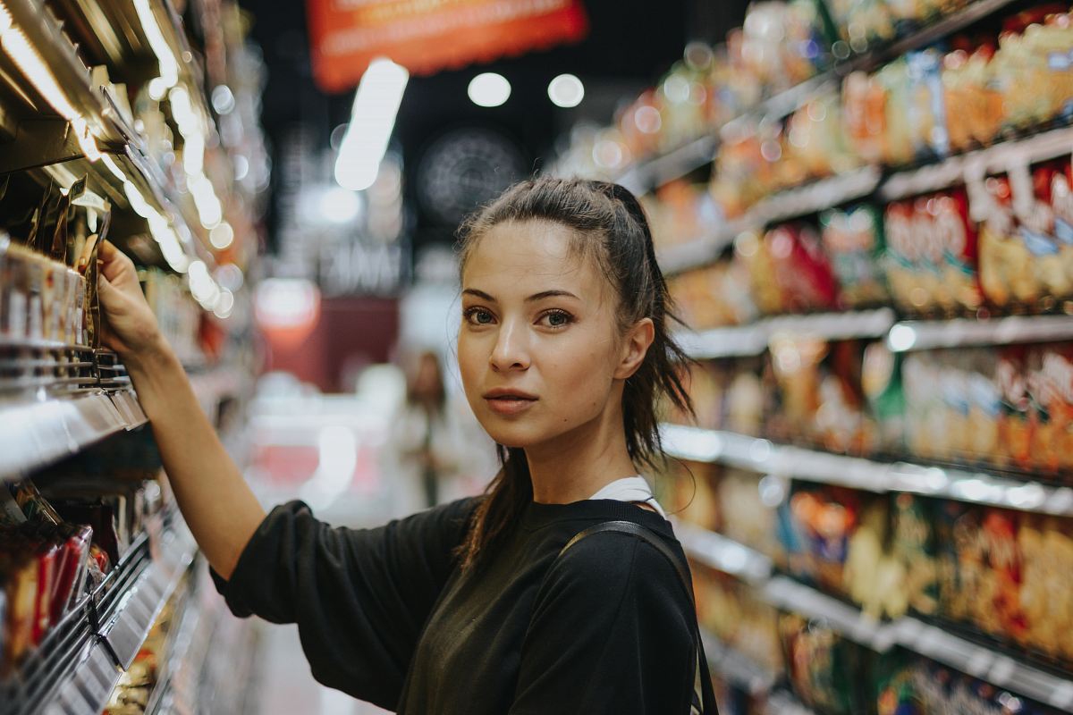 woman selecting packed food on gondola