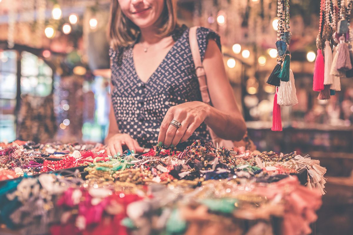 woman standing beside table of accessories