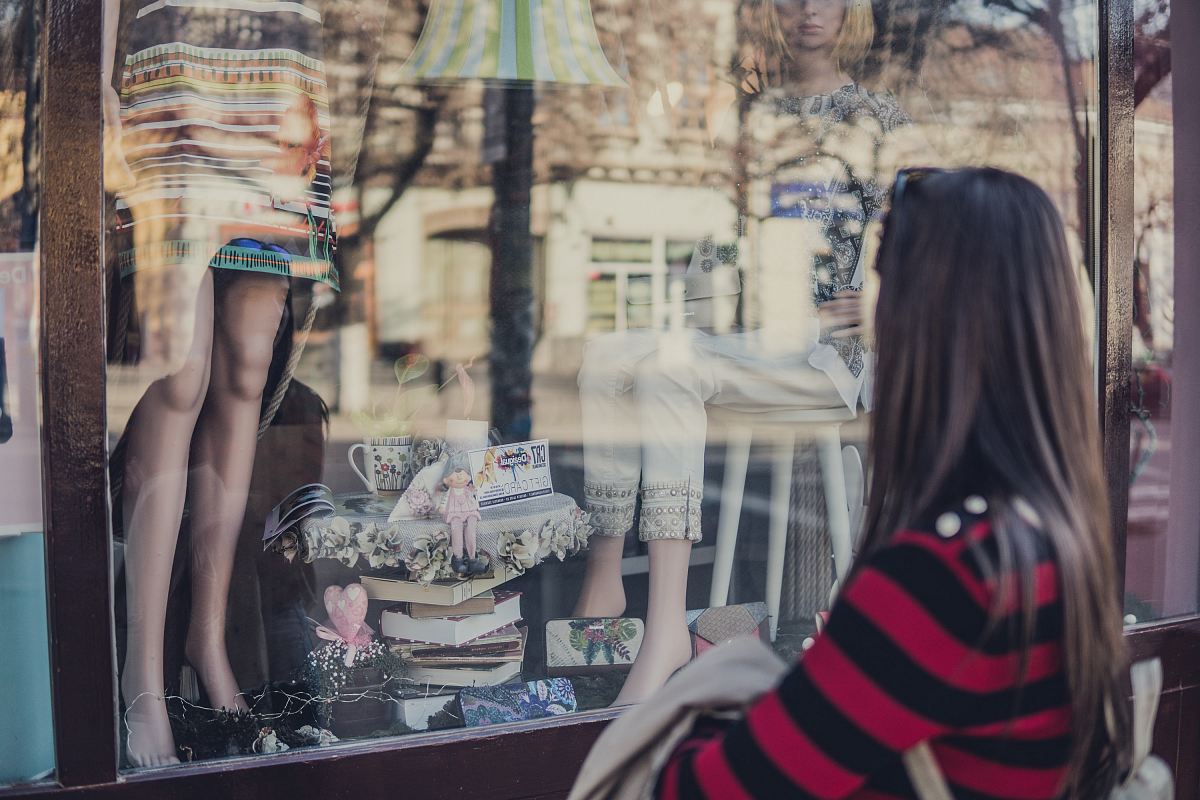 woman standing near store while looking at the mannequin