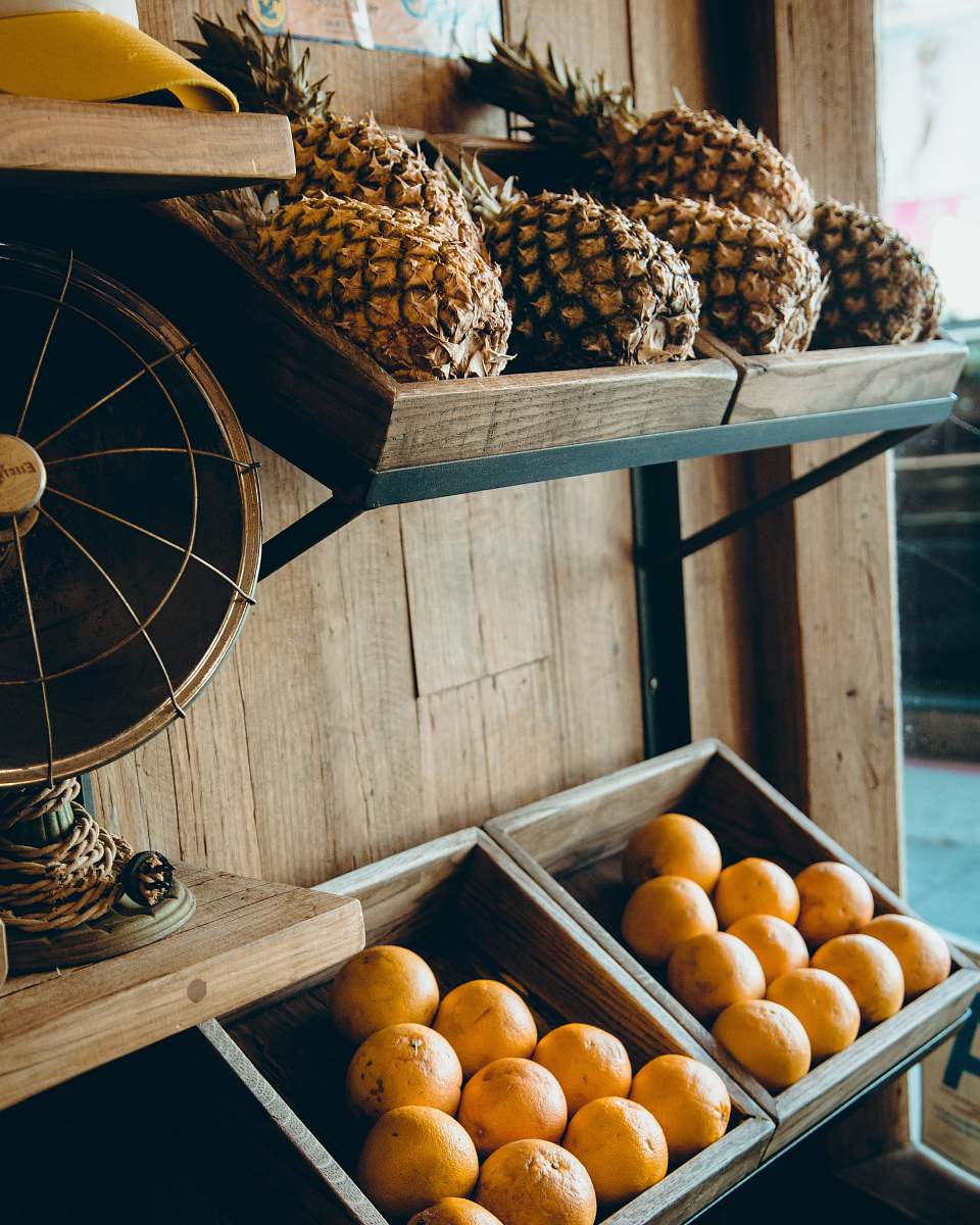 food pineapple and orange fruits on brown wooden rack orange