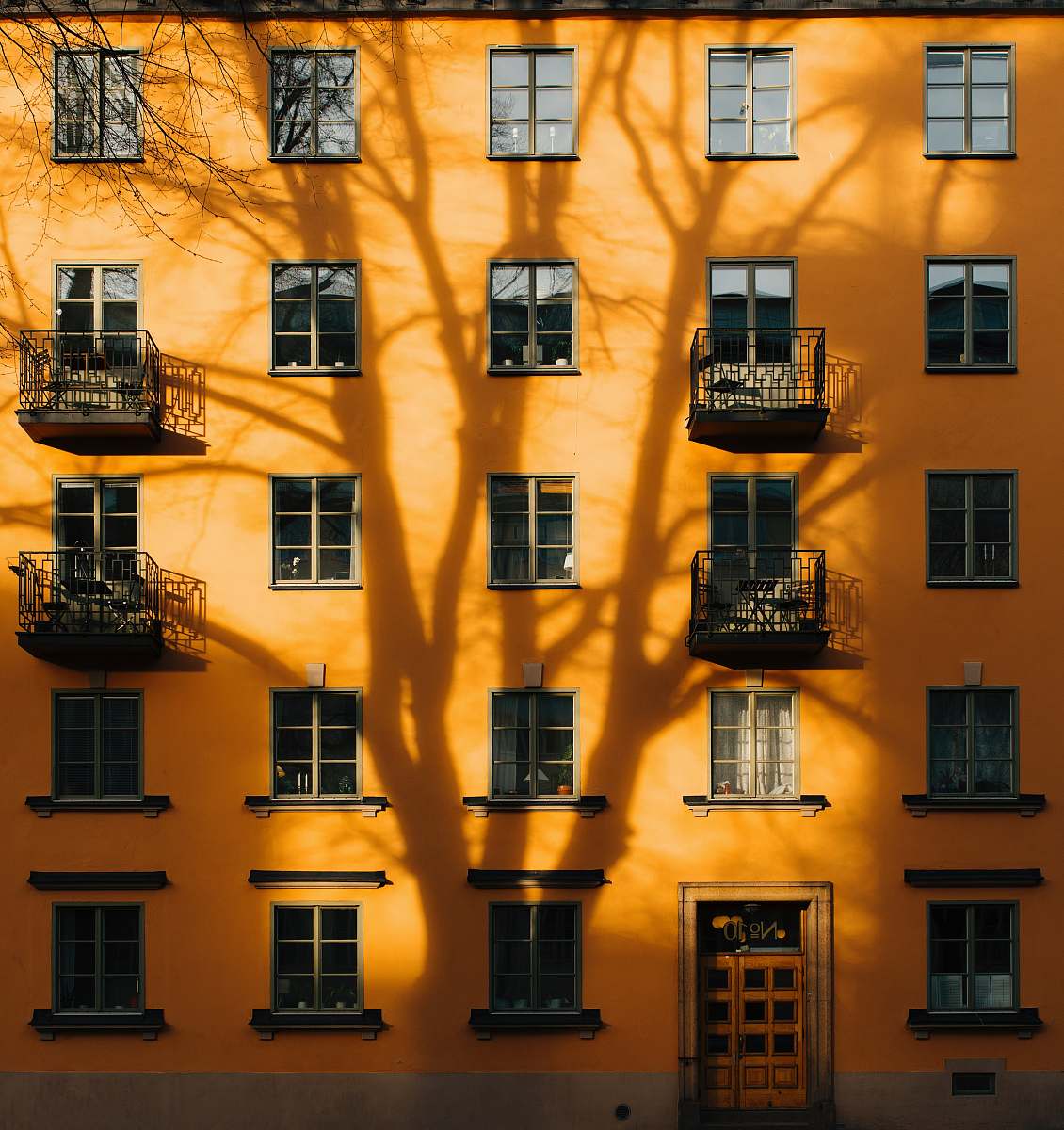 building orange concrete building with tree shadow during daytime stockholm