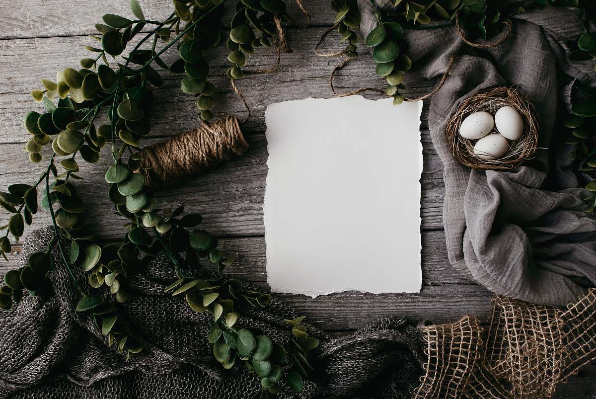 plant white paper, eggs on nest, and brown thread inside leaf and mesh wreath wreath