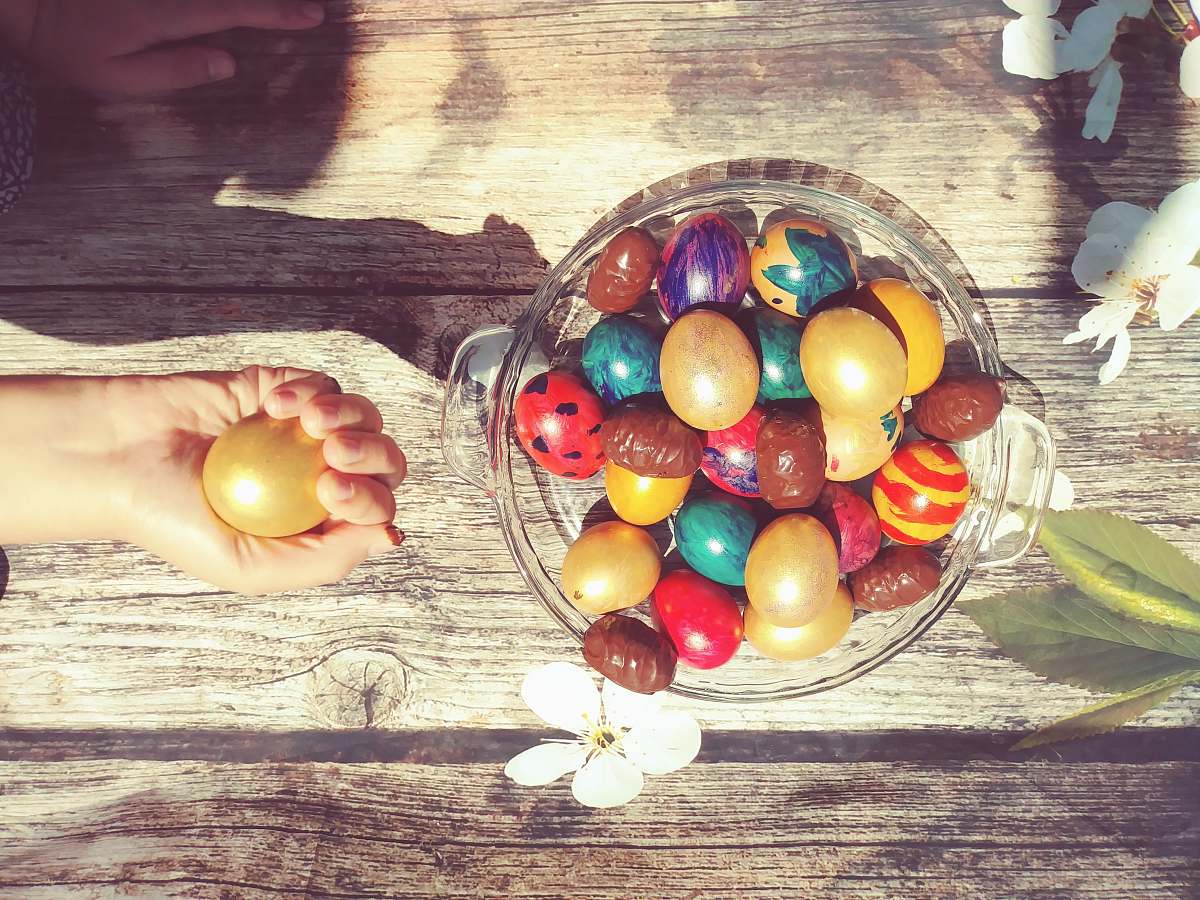 egg bowl of assorted-color Easter eggs person