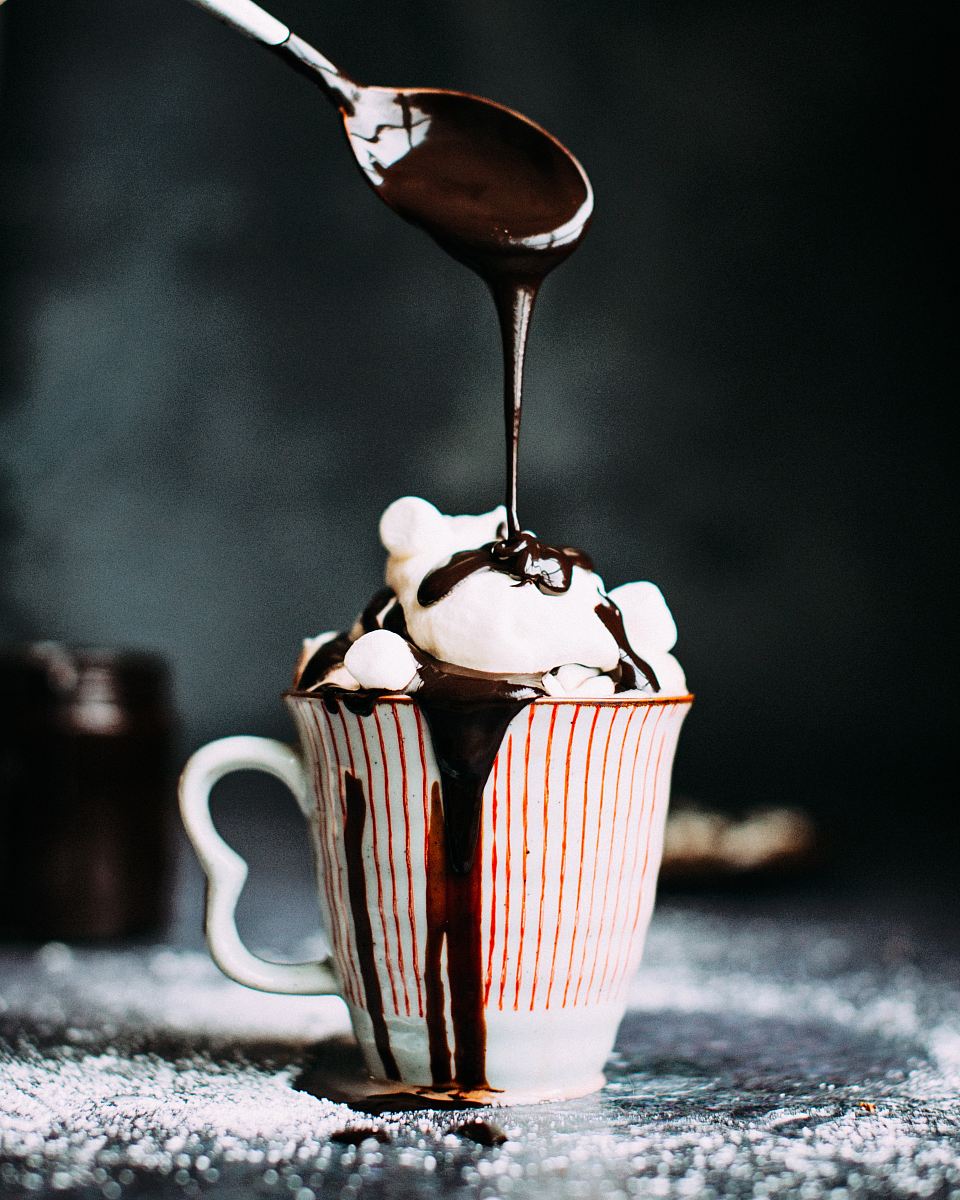 chocolate pouring on vanilla ice cream in ceramic cup