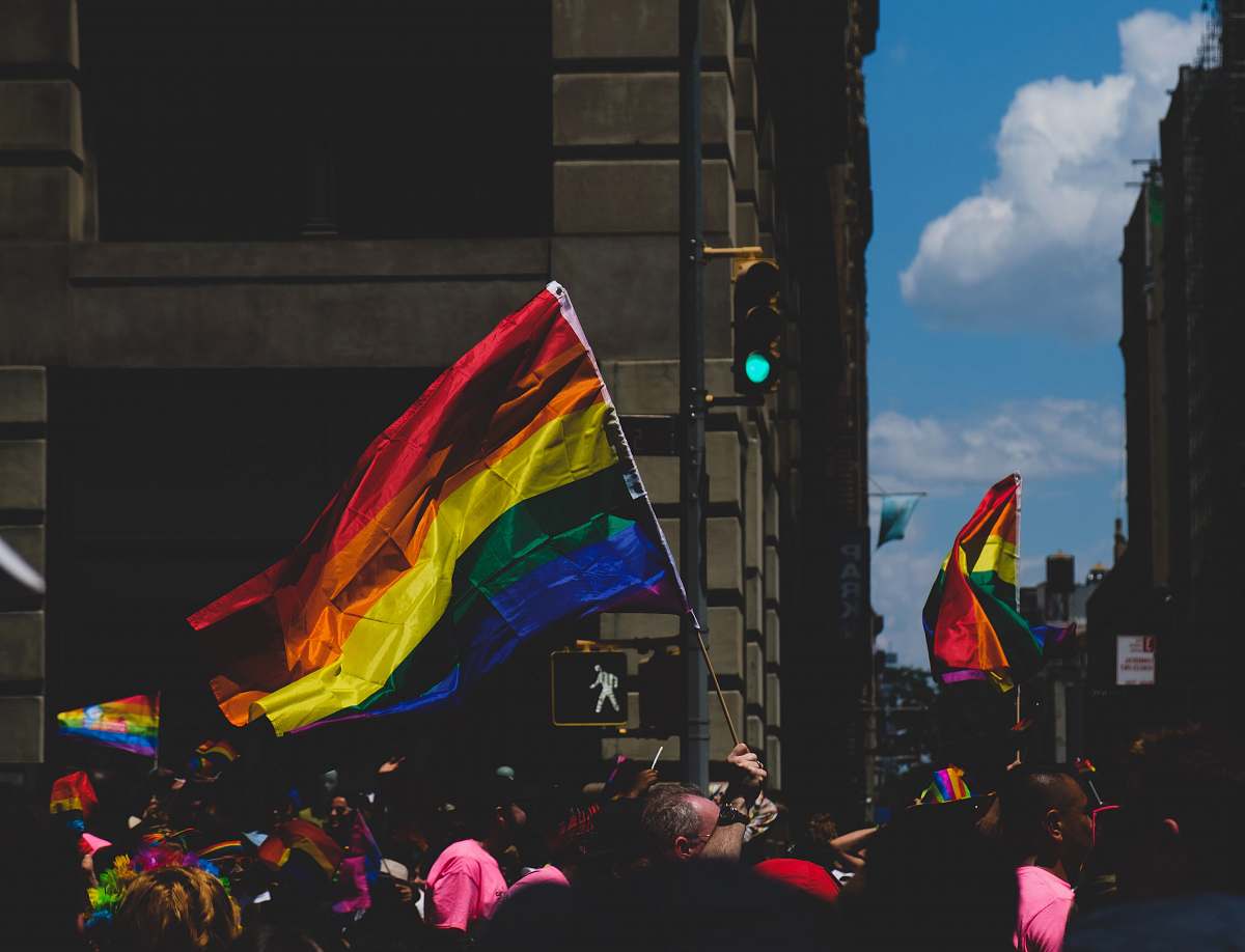 symbol community of LGBT rallying near street under white and blue sky during daytime light