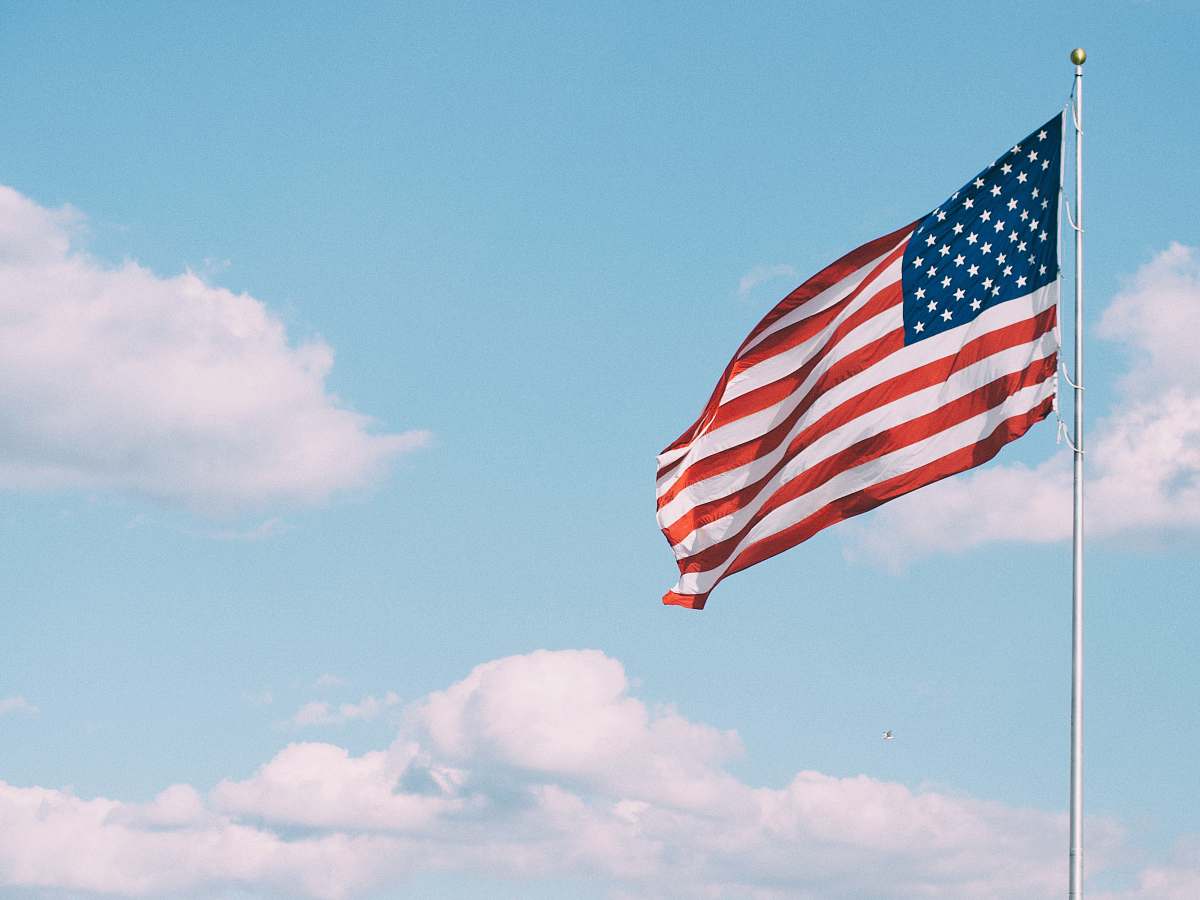 emblem flag of U.S.A. under white clouds during daytime america