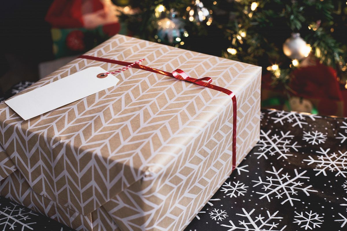gold and white gift box on black and white fair-isle print surface