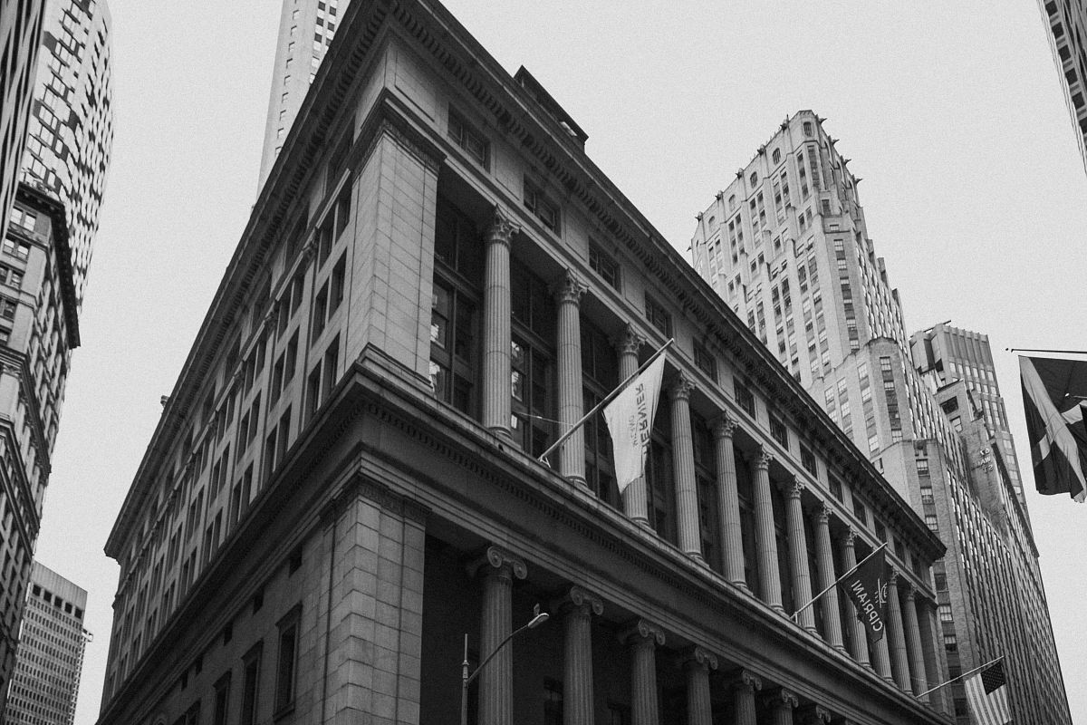 grayscale photography of waving flag hanged on building