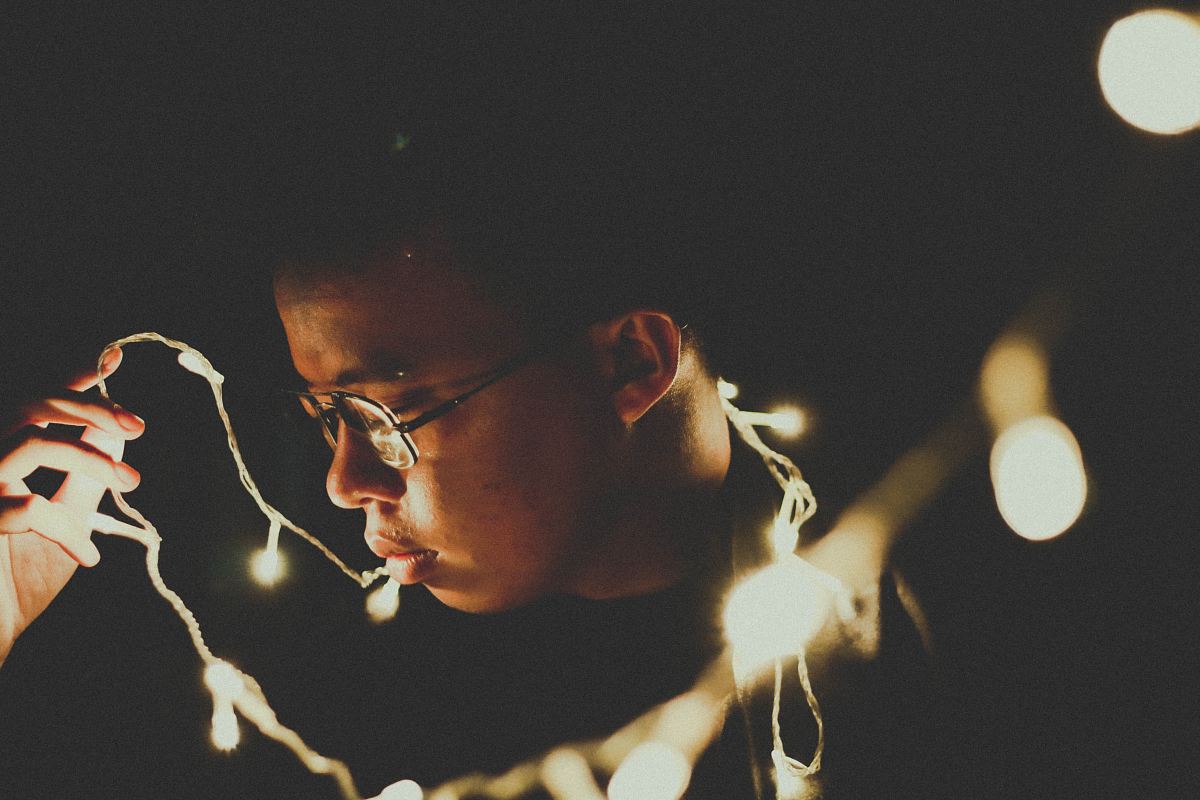 man holding string lights