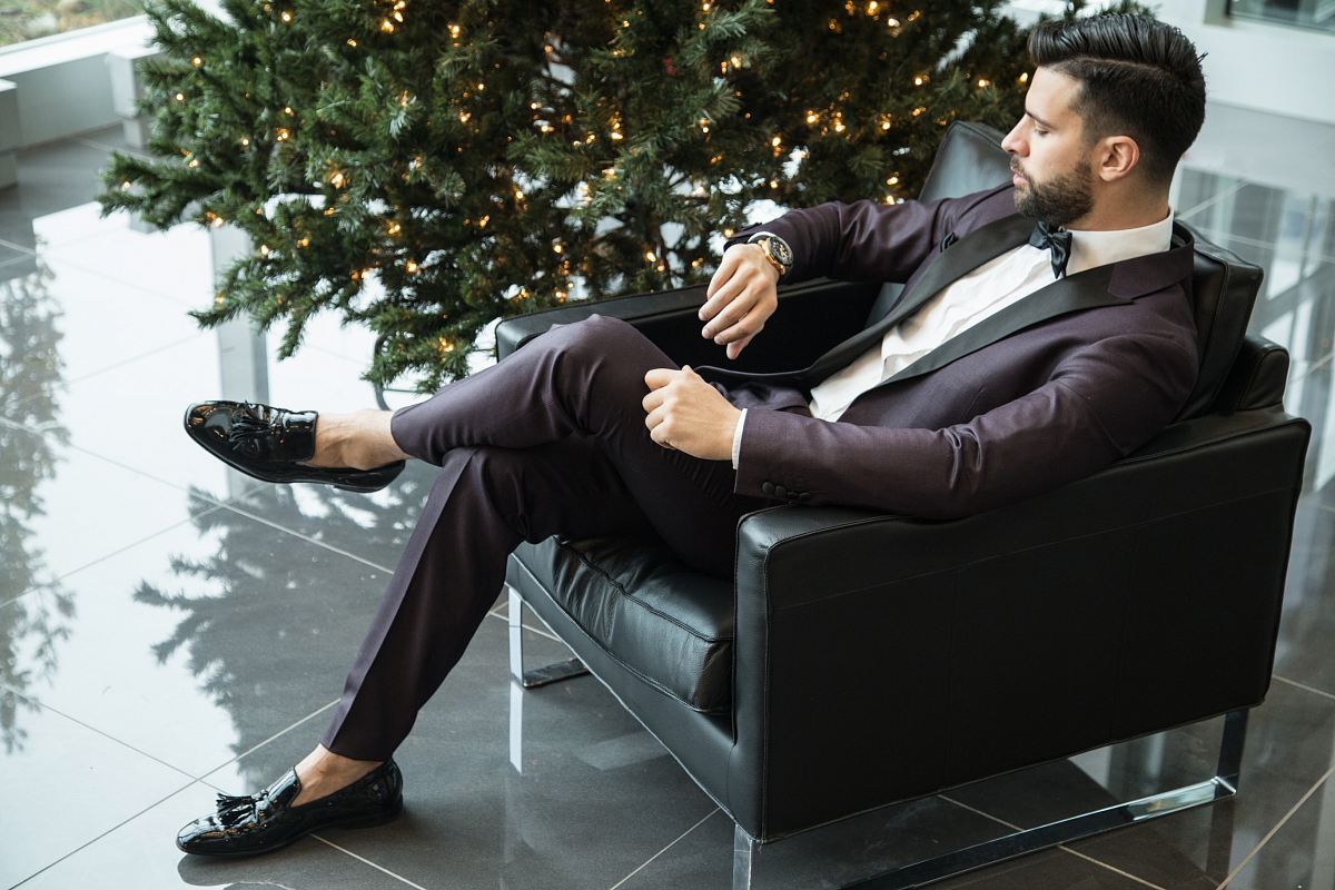 man sitting on black sofa chair while watching watch