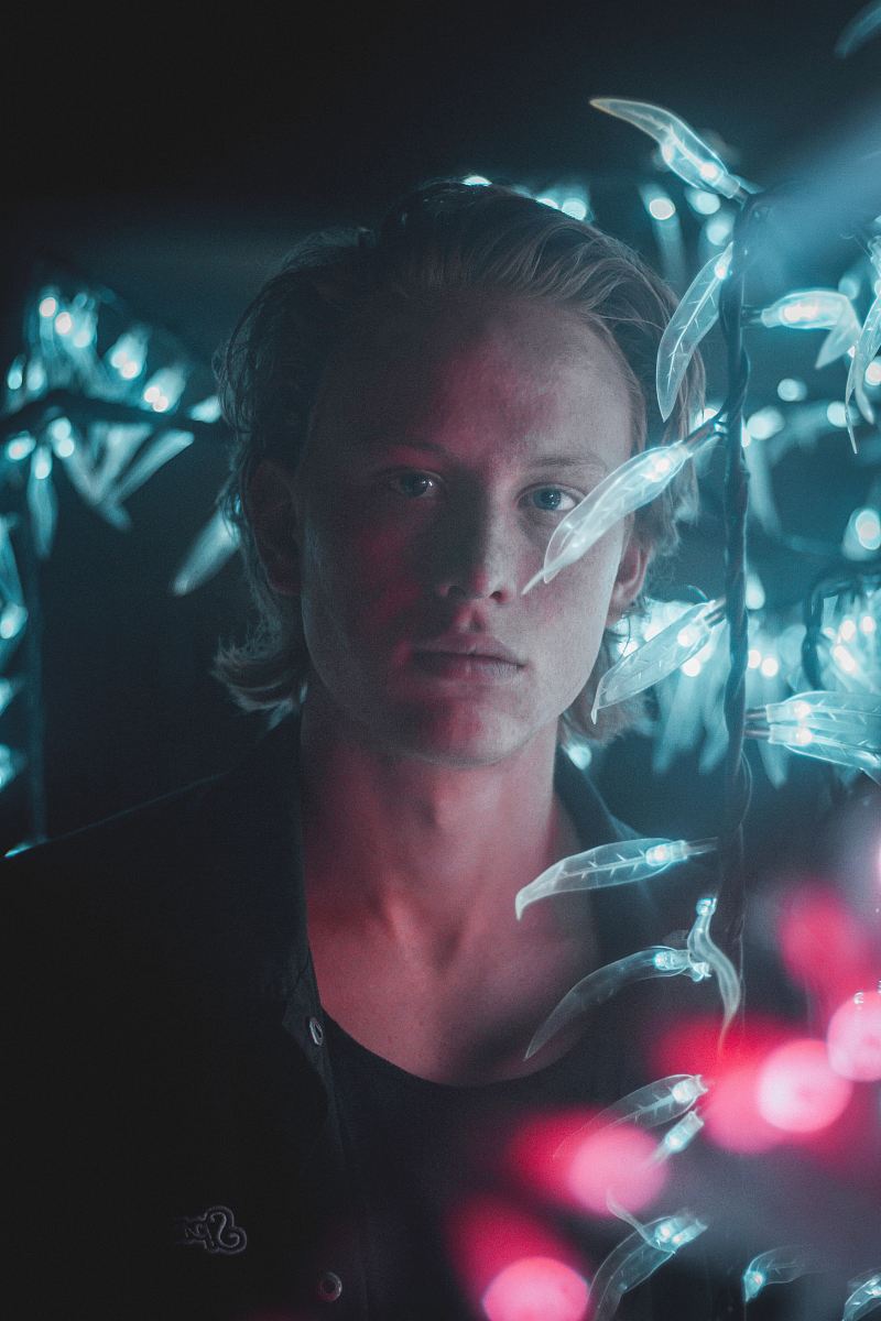 man wearing black shirt with string lights