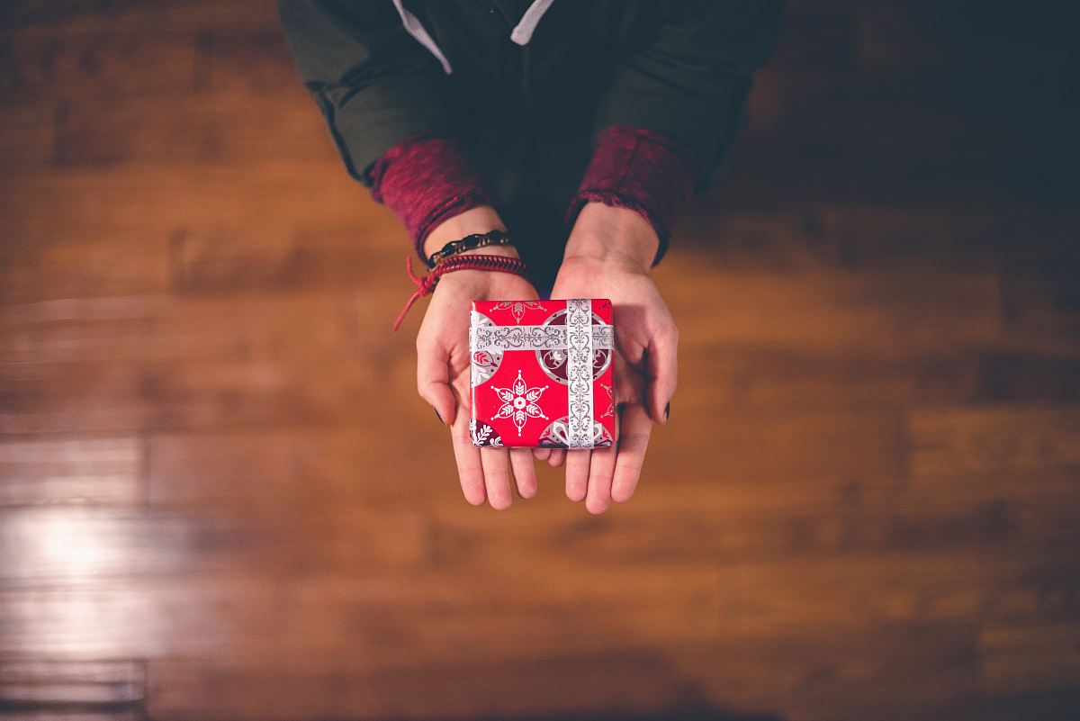 person holding red and white box