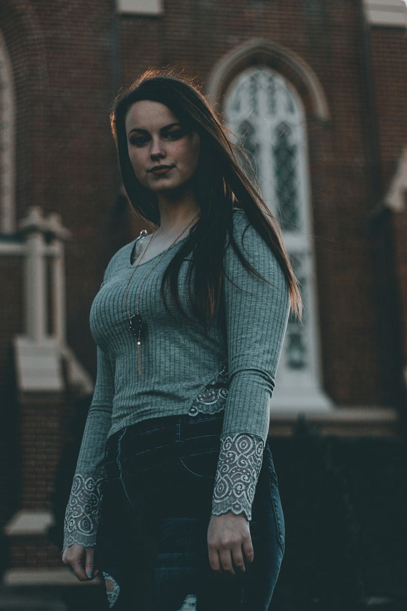 selective focus photo of woman standing near building
