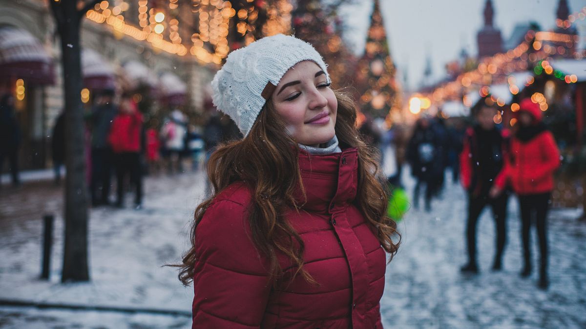 selective focus photography of woman wearing red parka jacket while standing