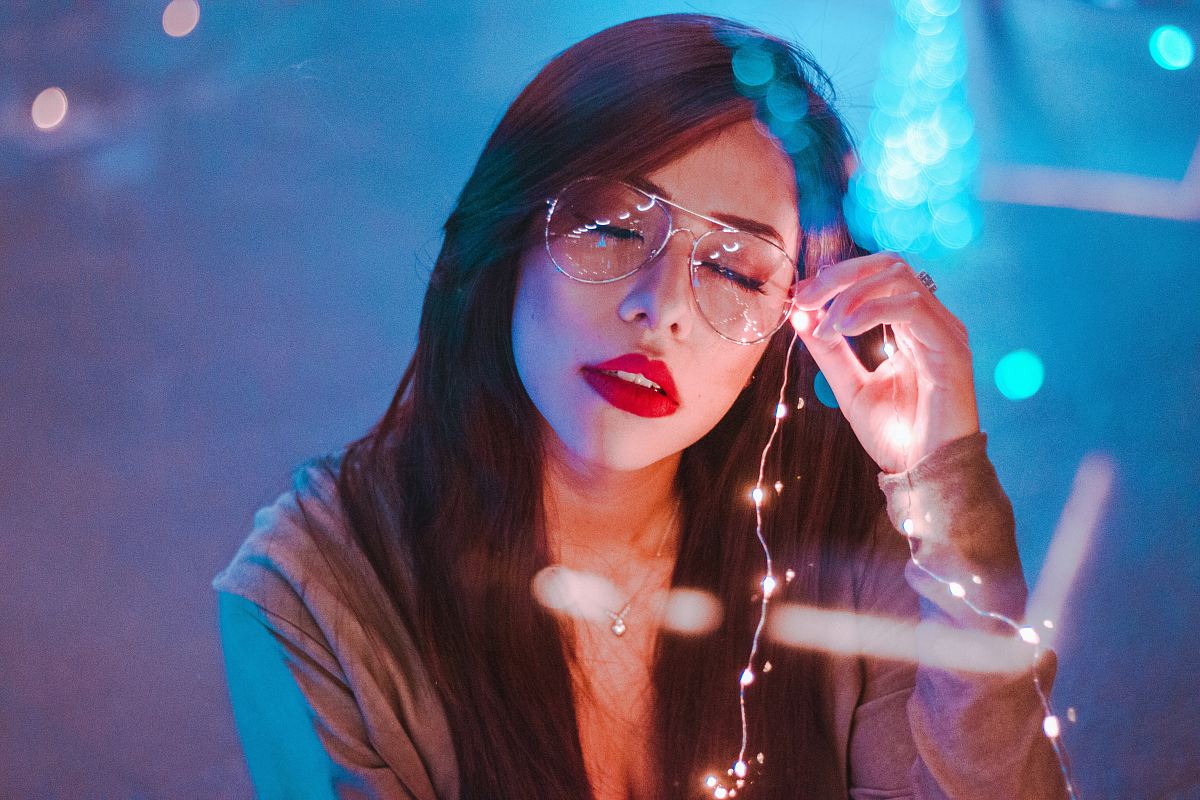 shallow focus photography of woman holding string lights