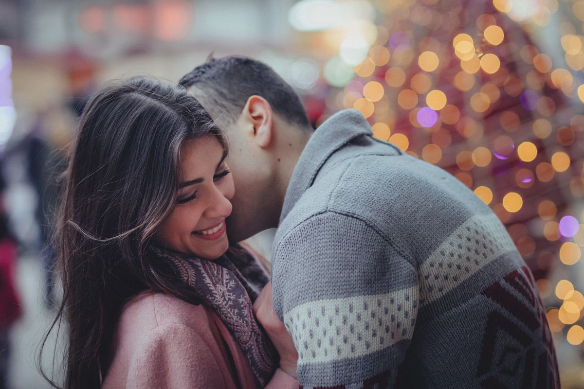 shallow photography of man hugging woman outdoors