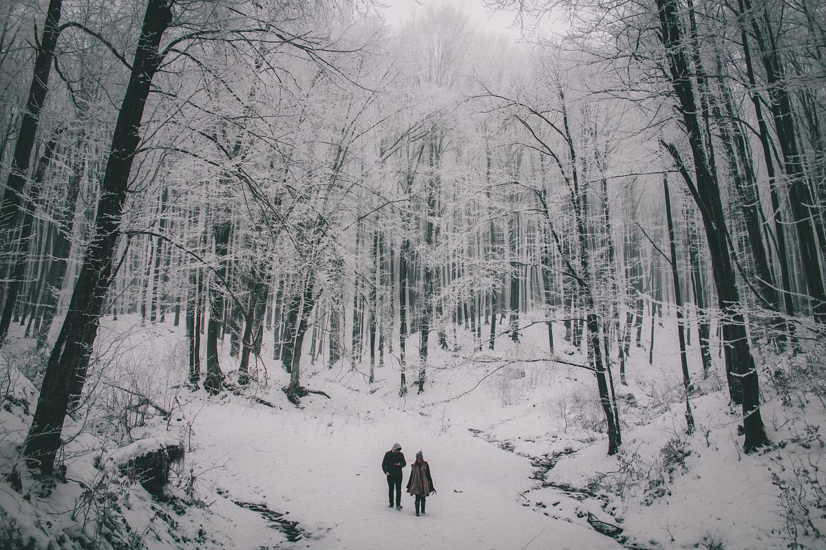 two person walking on snow