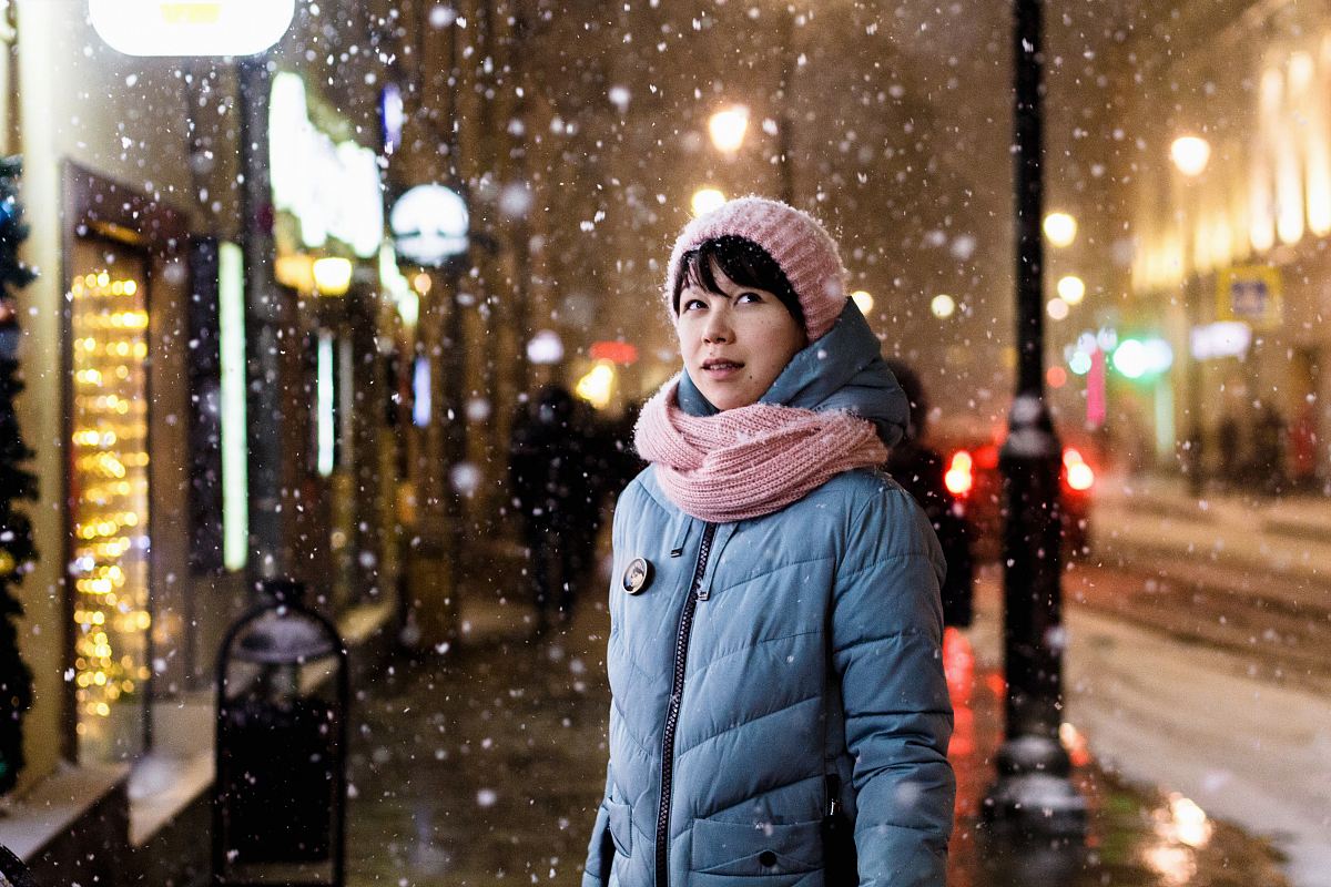 woman at the sidewalk near people and buildings during winter