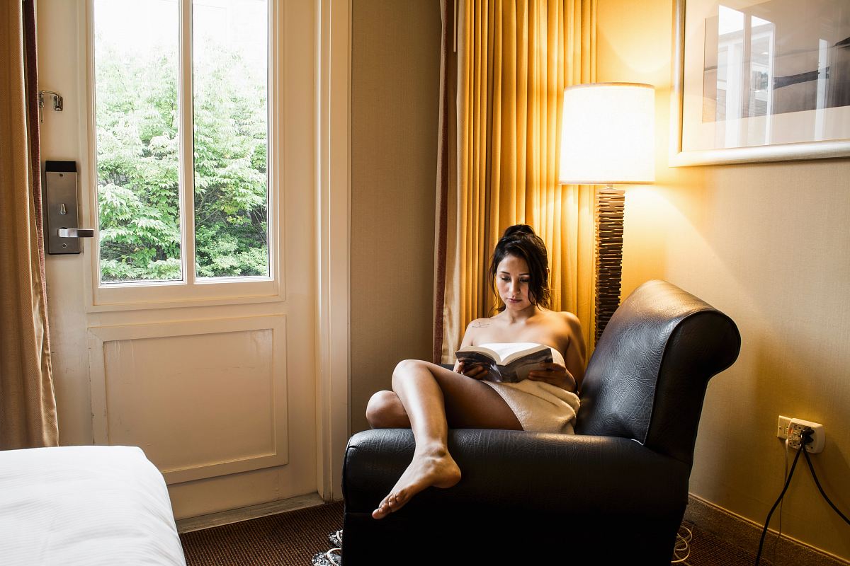 woman reading book on chair